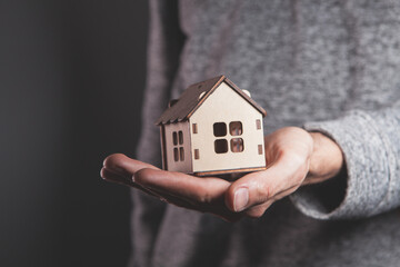 a man in the house holding a model of a brown cardboard