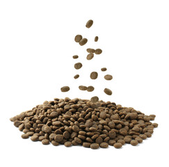 Dry pet food falling onto heap on white background