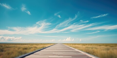 A Long Wooden Walkway Leads to a Serene Expanse of Grass Under a Vast, Blue Sky with Wispy Clouds