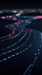 Fototapeta premium A winding road illuminated by lights at night, creating a dynamic visual path.
