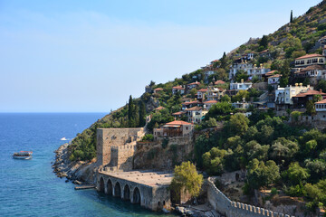 Fototapeta premium a city is surrounded by a mountain and the water is blue 