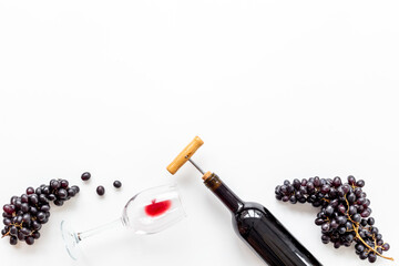 Red wine in the bottle with bunch of grapes and glass, top view