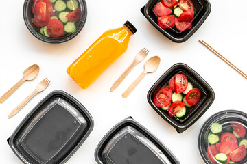 Healthy food delivery in takeaway boxes with and disposable cutlery, top view