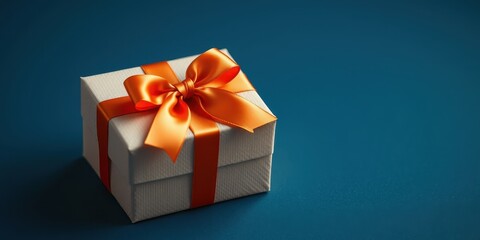 Obraz premium A small, elegant gift box with an orange ribbon, ideal for a special occasion or celebration.