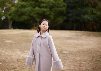 冬の朝の公園で元気で楽しく遊んでいる小学生の女の子の様子