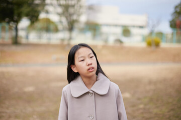 冬の朝の公園で元気で楽しく遊んでいる小学生の女の子の様子