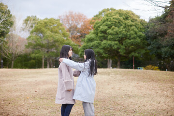 冬の朝の公園で元気で楽しく遊んでいる子供姉妹の姿