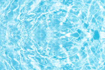 Blue water with ripples on the surface. Defocus blurred transparent blue colored clear calm water surface texture with splashes and bubbles. Water waves with shining pattern texture background.