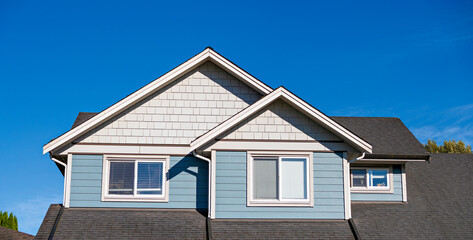 Top storey of residential house on blue sky background