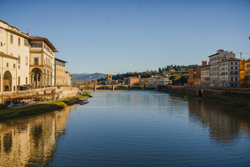 Fototapeta premium The embankment of the Arno River in Florence. Renaissance architecture. Reflection of houses in the water. Florence Bridge: Ponte Vecchio