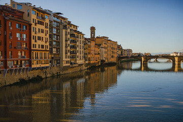 Obraz premium The embankment of the Arno River in Florence. Renaissance architecture. Reflection of houses in the water. Florence Bridge: Ponte Vecchio