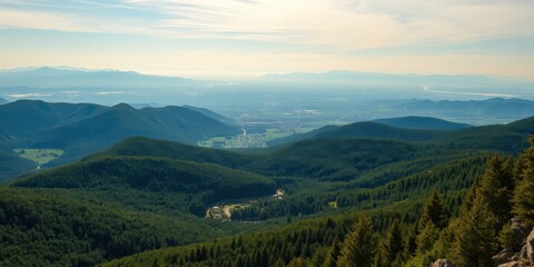Obraz premium Serene mountain vista overlooking a distant valley and town, showcasing rolling hills and lush evergreen forests
