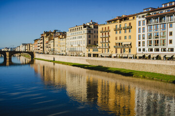 The embankment of the Arno River in Florence. Renaissance architecture. Reflection of houses in the water. Florence Bridge: Ponte Vecchio