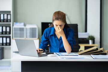 Serious woman cover her face after stressed with credit card debt sit at workplace desk in office...