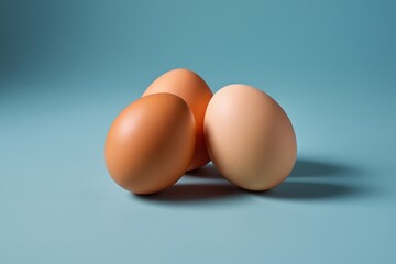 three eggs are sitting on a blue surface with one egg in the middle