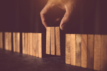 Hand place wooden block stack in pyramid stair step concept team building of prevent not collapse...