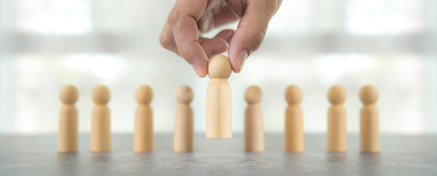 Hand choose wooden person for HR human resources or personal leader training skill or leadership and challenge business team player and organization management teamwork.