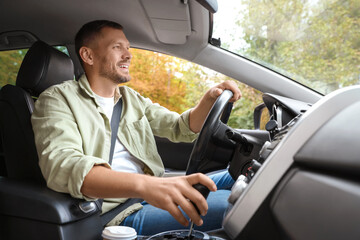 Happy man behind steering wheel of modern car