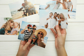 Woman with different photos at white wooden table, top view