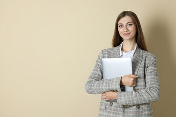 Fototapeta premium Portrait of smiling banker with laptop on beige background. Space for text