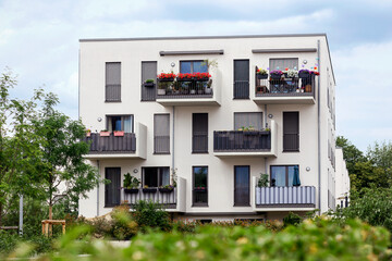 Residential Modern Building with White Facade and Green Landscaping in Germany. Comfort Multifamily Low rise, High rise Block of Flats or Apartment Building. New Living Building.