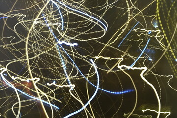 Artistic light trails forming intricate abstract patterns in blue and yellow hues. 