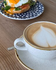Toast with fried egg, greens, and vegetables on a blue plate.