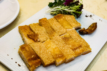 Close up of Chinese Cantonese style crispy boneless chicken with stuffed minced shrimp with sesame on top and cut into pieces 