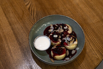 cottage cheese pancakes in a plate with berries and condensed milk