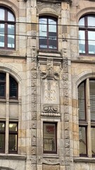 Obraz premium Detailed architecture of an old building with stone finishing and tall windows. Elements of Renaissance style, sculptural decor, and a sense of historical atmosphere.
