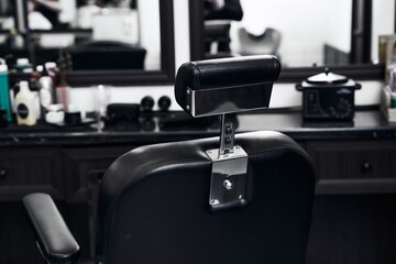 Black barber chair in a stylish salon with modern decor and tools