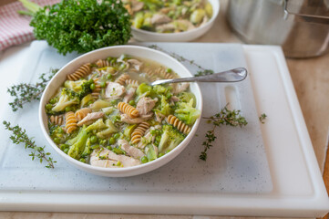 Healthy chicken soup with green vegetables and whole wheat pasta