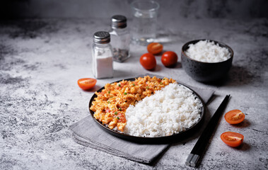 Tomato and eggs stir fry with rice in a plate