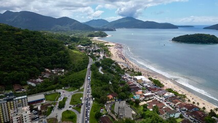 Vista panoramica do mar com fundo de casas e vegetação.