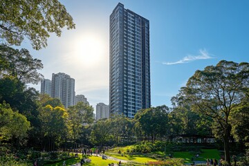 Fototapeta premium Modern green skyscraper with lush balconies overlooking urban skyline at sunset
