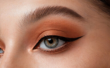 Obraz premium Close-Up Eye Makeup Winged Eyeliner Natural Brow Beauty Look Orange Eyeshadow Detail Cosmetic Perfection Glamorous Style Focused Vision Skincare Radiant Appearance Fashion Photography