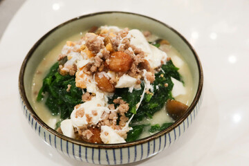 close up of Chinese Hong Kong Style Cantonese style preserved egg, salted egg minced pork with soup braised vegetables