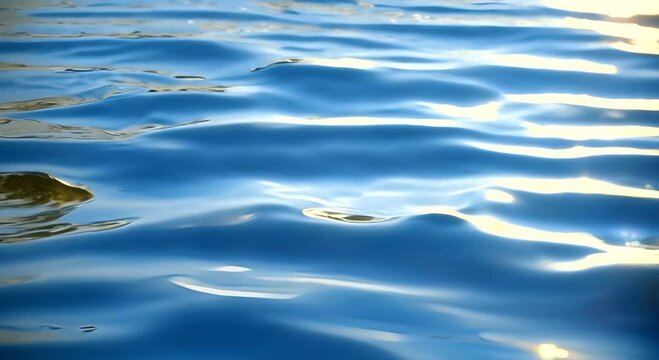 Close-up of shallow water surface with soft ripples and sunlight glinting off the clear blue texture, creating a calming, loop able animation