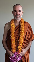 A Buddhist Monk Wearing an Orange Robe and Flower Garland