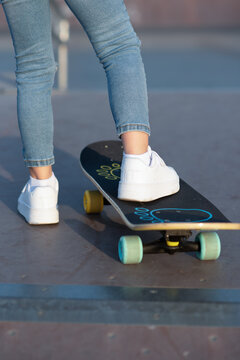 child's foot on a skateboard in a white sneaker rear view. High quality photo