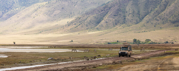 Tourist during jeep safari bird watching along Lake Magadi during rainy season in Ngorongoro Conservation Area in Tanzania, East Africa © Hilda Weges