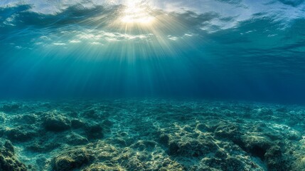 Fototapeta premium Dark blue ocean surface seen from underwater, light rays to the ocean ground, 16:9