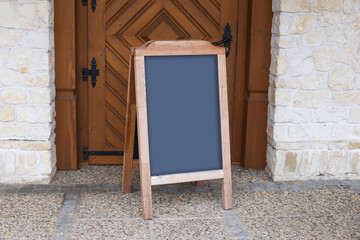 Wooden chalkboard sign. Empty copy space at the entrance of a restaurant. Blank board business...