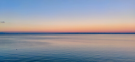 Obraz premium Peaceful Sunset Over Lake Constance with Pastel Skies and Tranquil Waters
