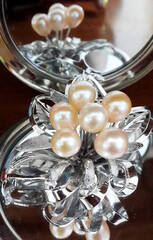 Elegant Pearl Brooch with Silver Accents and Reflection