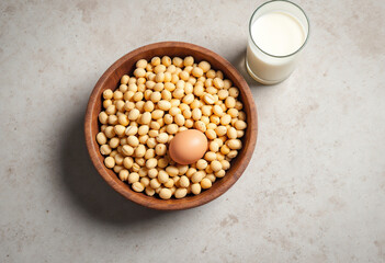 Raw Groundnuts in the wooden bowl, chicken egg and a glass of milk on cement background.