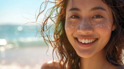A smiling girl on the beach with water splashing on her face is ideal for advertising cosmetics, travel agencies and summer clothing collections. It conveys a feeling of joy and carefree.