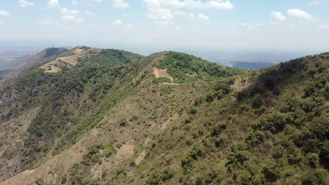 Aerial flyover of the Ngong Hills in Kenya with Nairobi in the background.