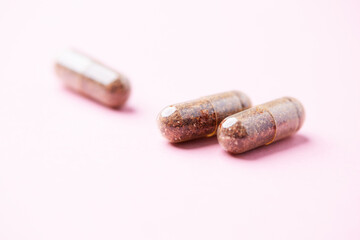 Siberian ginseng (Eleutherococcus senticosus) capsules on bright background. Soft focus. Close up. Copy space. 