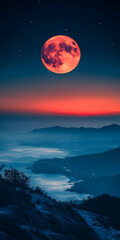 Blood moon rises over misty mountains at night.